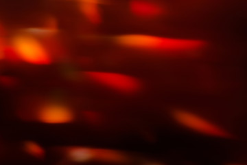 abstract lens flare on black background. red defocused bokeh lights. blurred christmas wallpaper decor. festive glowing splotch design.