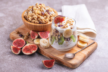 Granola with yogurt, bananas and figs. Copy space