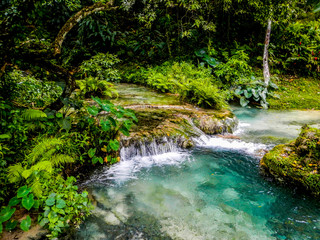 Water flows down the Mele Cascades waterfalls among lush jungle in Efate Island, Vanuatu, near Port Vila