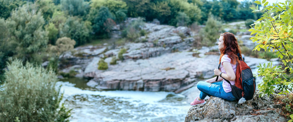 Woman traveler looking at natural canyon with view of the mountain river. Concept of travel.