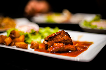 Beefsteak with BBQ sauce on with fried potatoes and salad