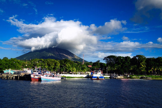 OMETEPE, NICARAGUA - Dec 2015: Moyogalpa port on Ometepe Island in Lake Nicaragua with fishing boats and cloud-topped Concepcion volcano in the background
