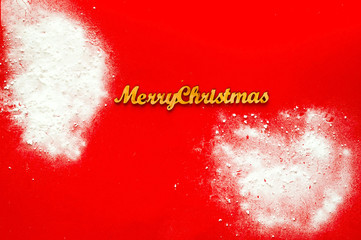 Christmas decor, Decorative wooden inscription merry Christmas on  red background  with snow, concept of New Years holiday, copy space,top view