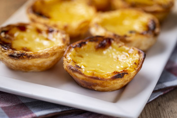 Typical Portuguese custard pies - "Pastel de Nata" or "Pastel de Belem". traditional portuguese pastry. On a wooden table.