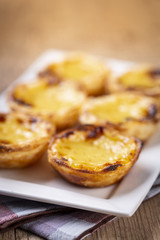 Typical Portuguese custard pies - "Pastel de Nata" or "Pastel de Belem". traditional portuguese pastry. On a wooden table.