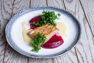 Delicious mediterranean seafood. Fish with green salad on a white plate