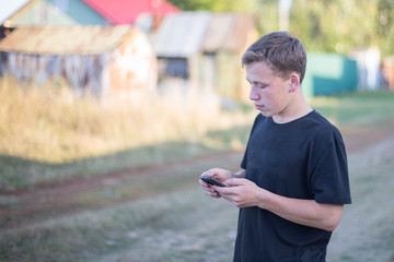 a young man in a black T-shirt is playing on the phone