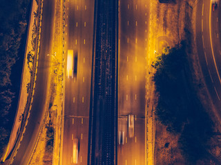 Top view from drone to city roads or highways with moving cars in the night