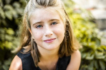 Fototapeta premium Portrait of russian girl in the park. Kids faces. Girl in black dress
