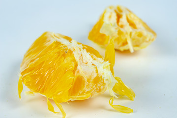 Peeled orange with very thick skin on a white kitchen table. Citruses prepared for desserts.