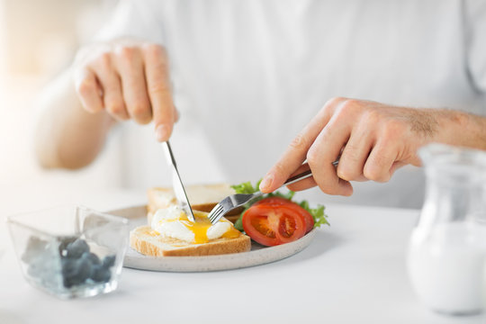 Food, Eating And People Concept - Close Up Of Man Having Toasts With Poached Egg And Vegetables For Breakfast