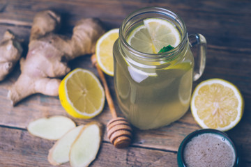 Hot drink with honey, lemon and ginger on wooden background. Concept of natural medicine. Winter or autumn drinks.