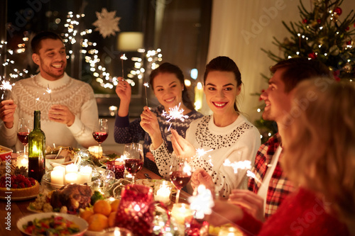 winter holidays and people concept happy friends with sparklers celebrating christmas at home feast - Celebrating Christmas winter holidays and people concept happy friends with sparklers celebrating christmas at home feast - Celebrating Christmas