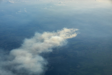 Naklejka na ściany i meble Aerial view of smoldering moor fire ignited by training activites on an army shooting range causing large smoke plumes