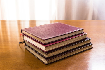 Hard cover books organized over wooden table