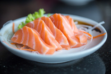 Fresh salmon slice and japanese on dish by lettuce and radish. Clean and fresh food for healthy concept.