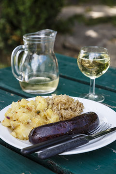 Blood sausage with potatoes and onions with white wine at a traditional restaurant and wine bar in the 19th district, Vienna, Austria.