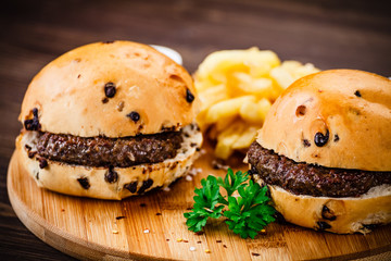 Tasty burger with chips served on cutting board
