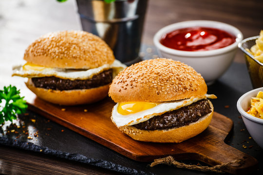 Tasty burger with chips served on cutting board