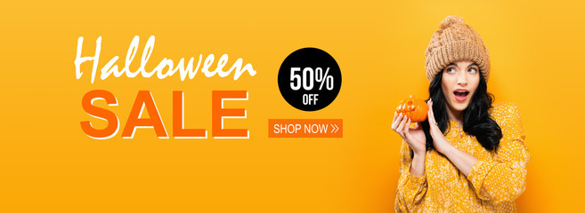 Halloween sale with young woman holding a pumpkin