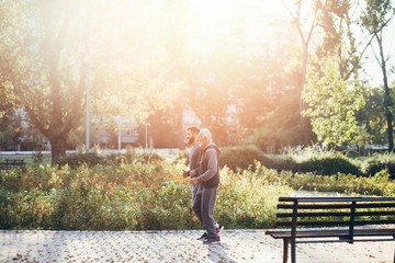 Fototapeta premium Happy father and son jogging together outdoors in park.