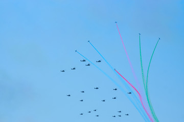 Military helicopters maneuvers in the blue sky. Group combat helicopters in flight during a military demonstration