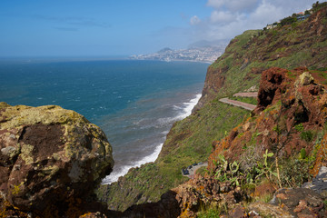View of the coastline of Caniço, Madeira with Funchal city on the background