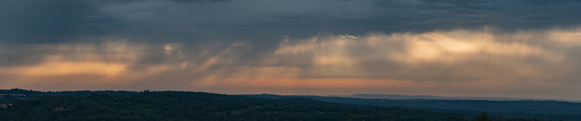 Stunning panoramic image of Summer sunset sky with colorful vibrant cloud formations