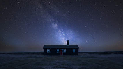 Vibrant Milky Way composite image over landscape of Remote desolate isolated house