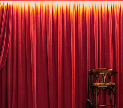 Wooden chair against the background of a red curtain