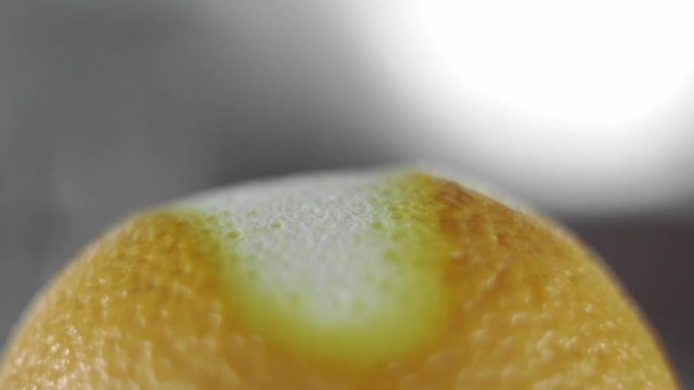 Removing of orange peel from the orange with a knife. Citrus zester grating peeling orange peel, oils spraying.