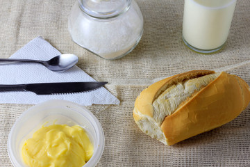 close up french bread on wooden breakfast table with butter and cutlery