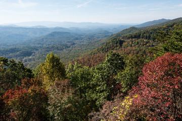 smoky mountains in autumn with blue sky and fog
