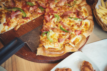 Fresh fragrant pizza and French fries on wooden plate