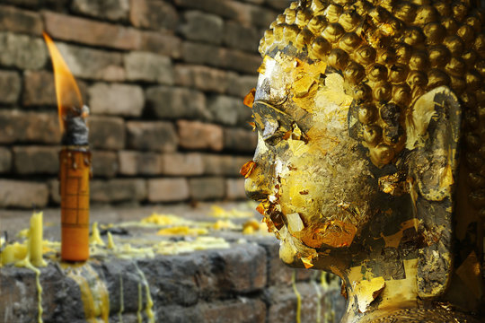  Head  of statue of buddha, with buddhist candle 