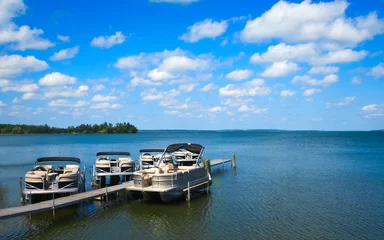 Fototapete Rund Boat dock with raised pontoons on beautiful lake in northern Minnesota with blue sky and fluffy clouds © scandamerican
