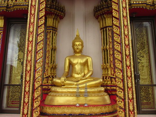Golden seated Buddha on pedestal in Thailand.