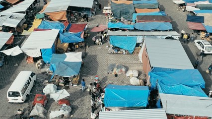 aerial drone image of the morning city market with colorful tents looking down