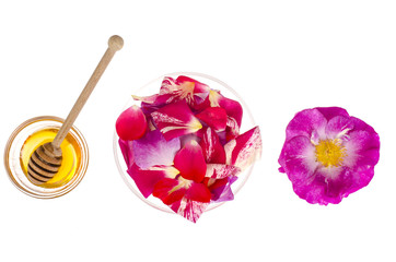 Rose petals and honey on white background