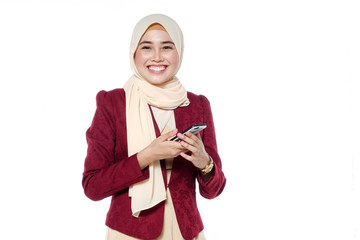 portrait of beautiful young Muslim woman using a mobile phone with a smile on a white background
