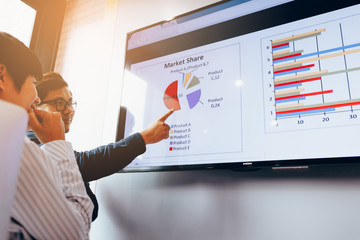 Close up two business people analysis chart working together at meeting room.