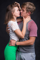 Lovers kissing each other on black background