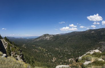 A view from South Lake Tahoe to a valley with trees, blue sky and white clouds