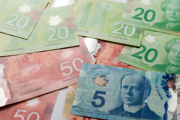 Paper notes from Canada. Dollar. Top view of bills spread and variation of amounts.