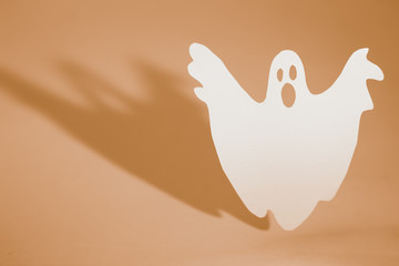Halloween background concept. Funny ghost doing boo gesture and graphic shade behind on orange...