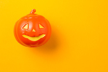 Halloween background concept. Minimal flat lay view of jack O pumpkin face on orange table