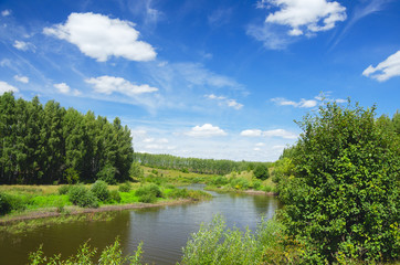 Obraz premium Sunny summer landscape with green hills,river curve and beautiful woods on a nice day.