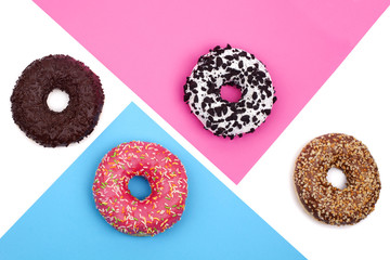 Fototapeta na wymiar Donuts on white, blue and pink background top view
