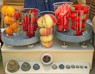 ancient scales with filled glasses of fresh fruits