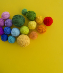 ball for knit rainbow color a yellow background.